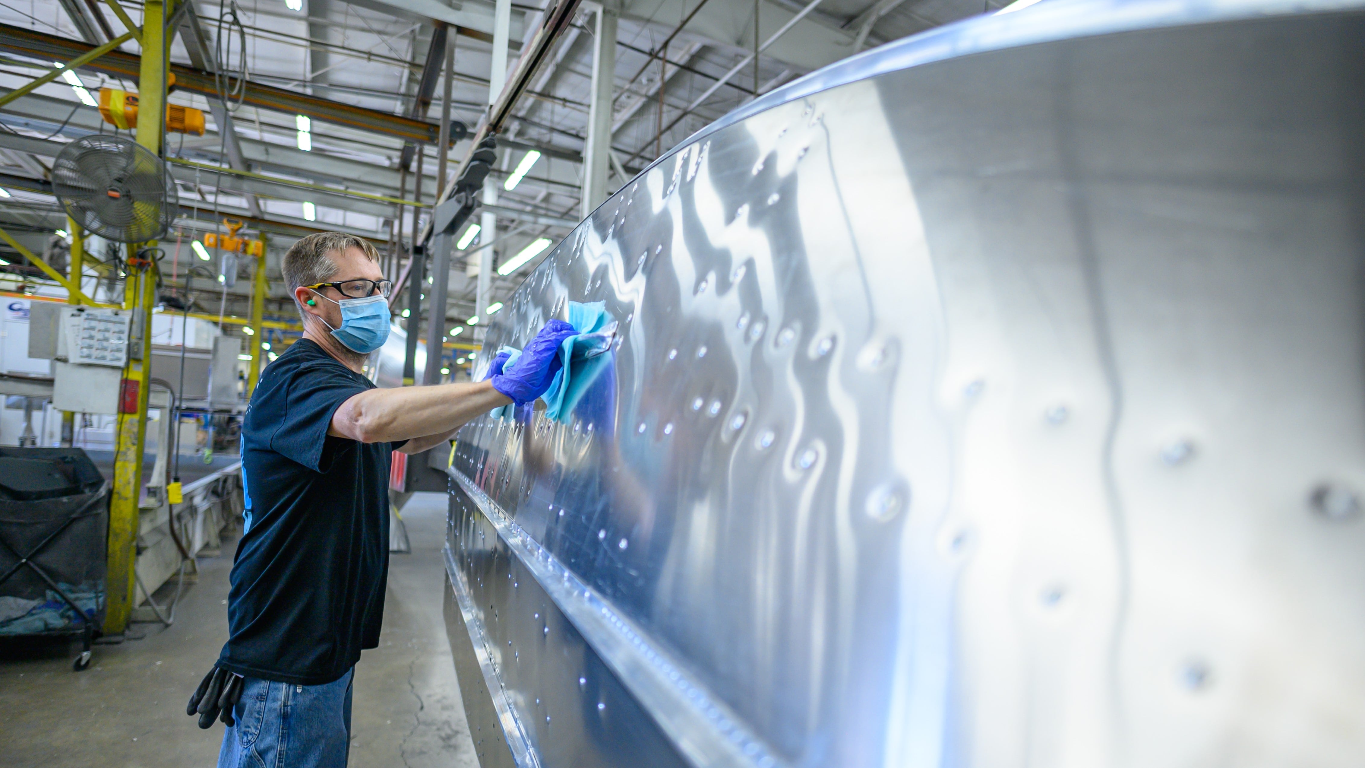 Homme travaillant sur la coque en aluminium d'un bateau Alumacraft