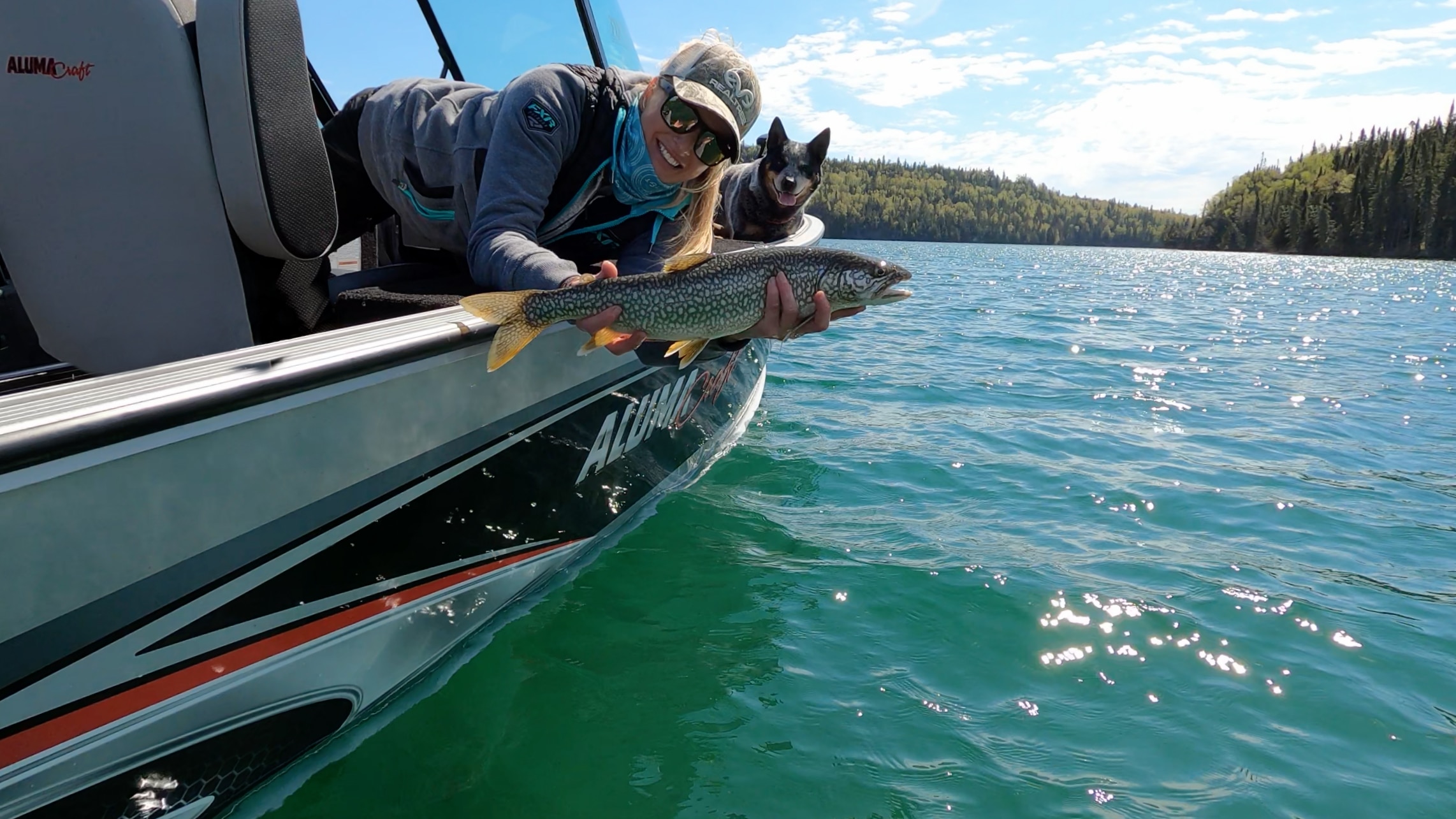 Rebekka Redd, et son chien, qui pêche à la truite de son bateau de pêche Alumacraft en aluminium