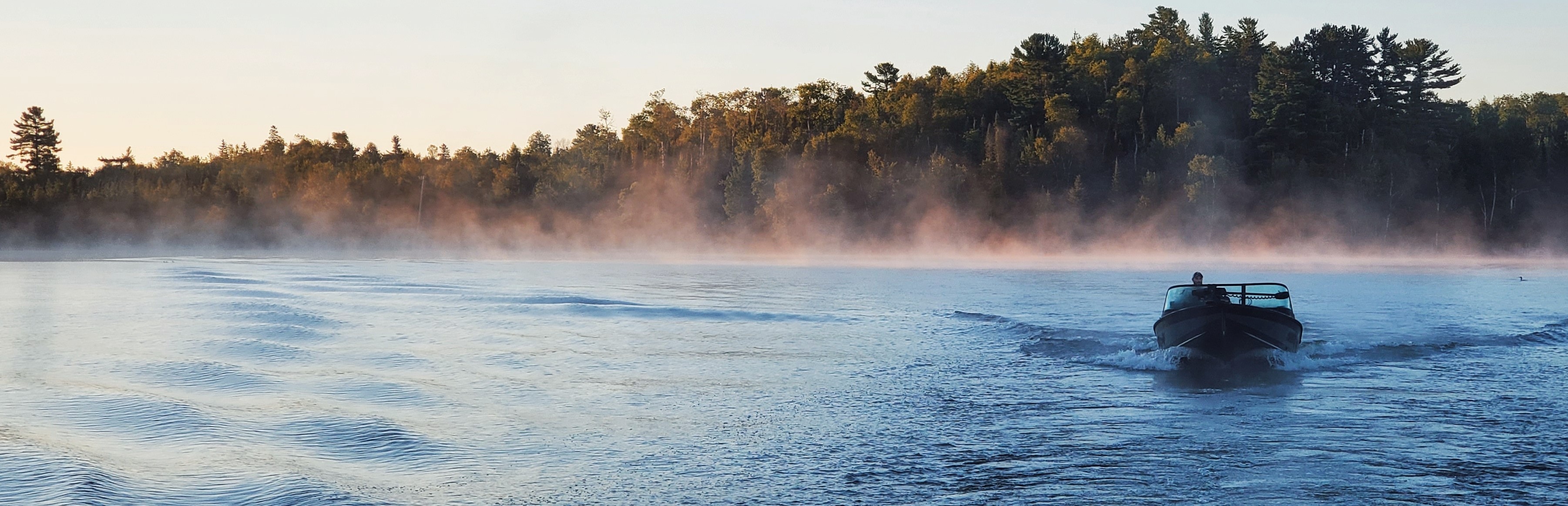 Alumacraft aluminum fishing boat on a lake at dawn