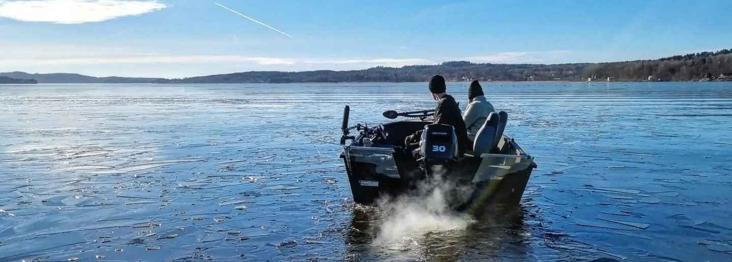 Deux amis pêchant sur un bateau alumacraft avec une fine couche de glace