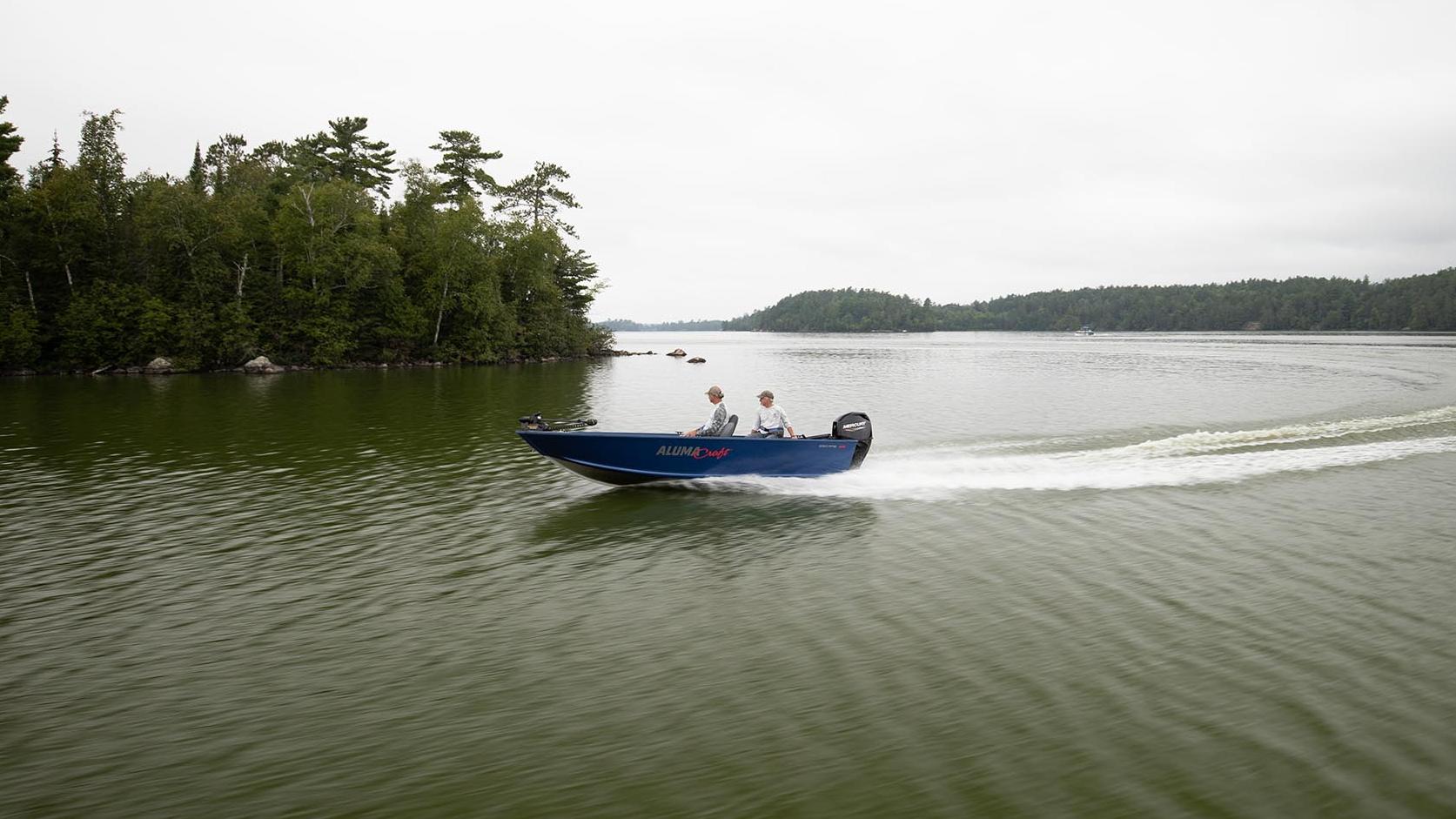 Couple fishing anglers driving boat to fishing spot