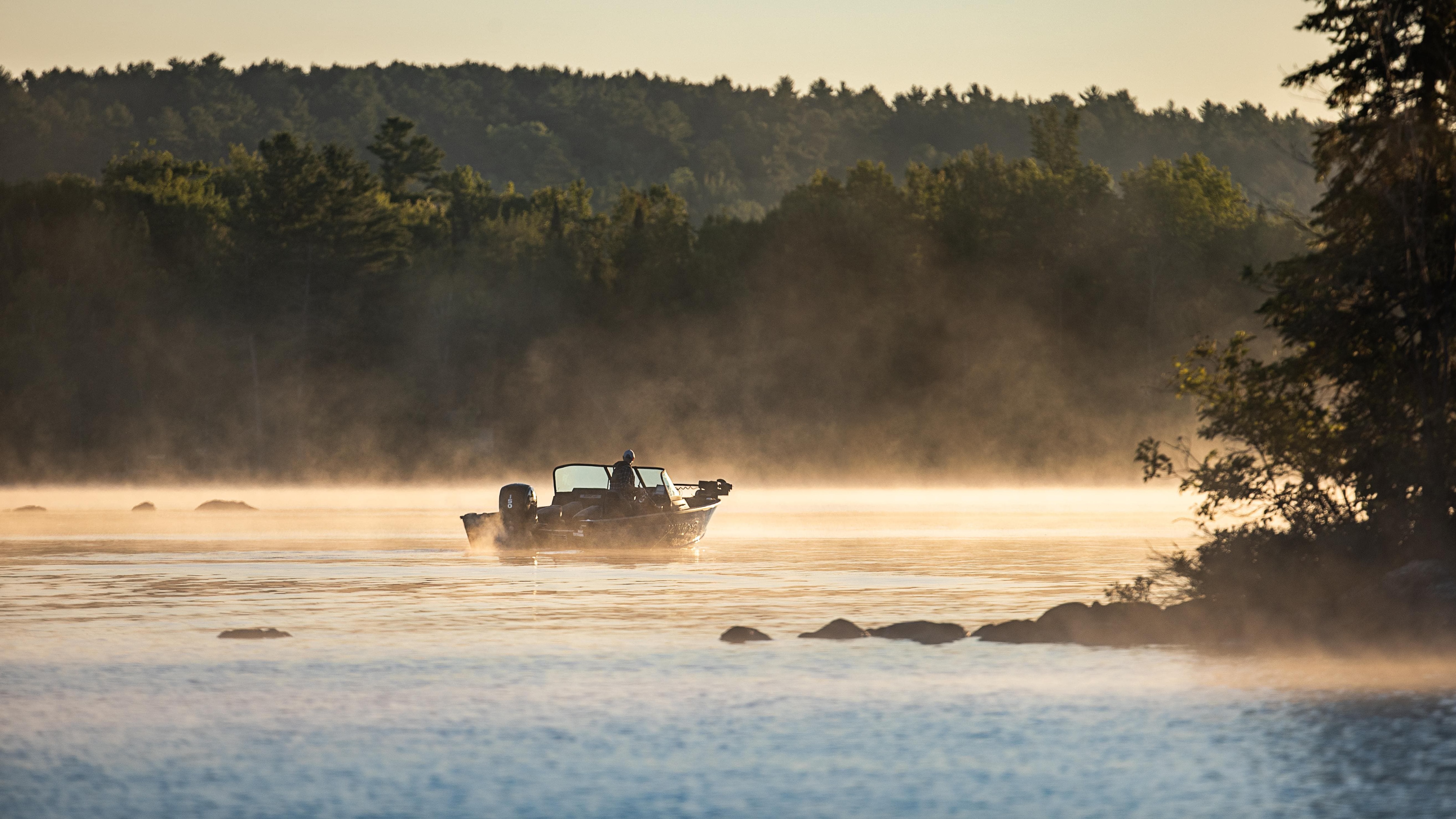 Aluminum boat sailing towards the sunrise
