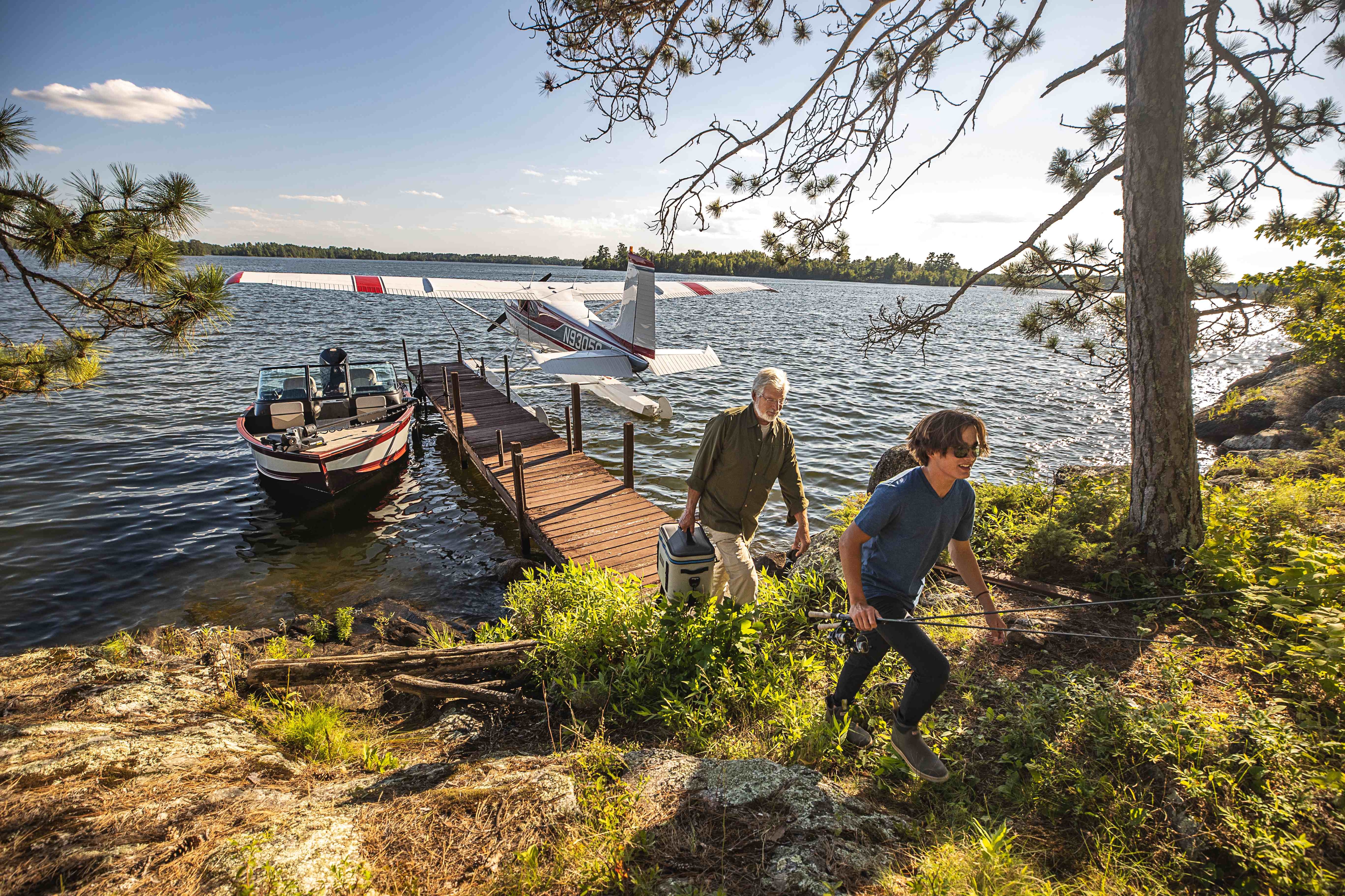 Men walking off a dock with a plane and a boat