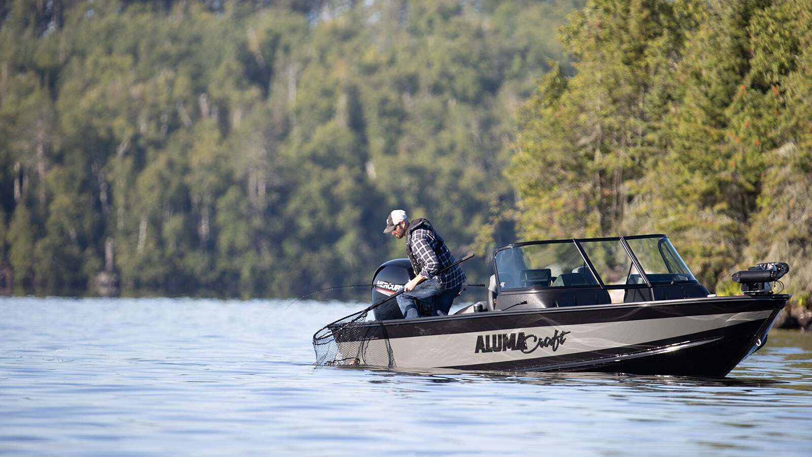 Fishing angler netting their catch in alumacraft competitor