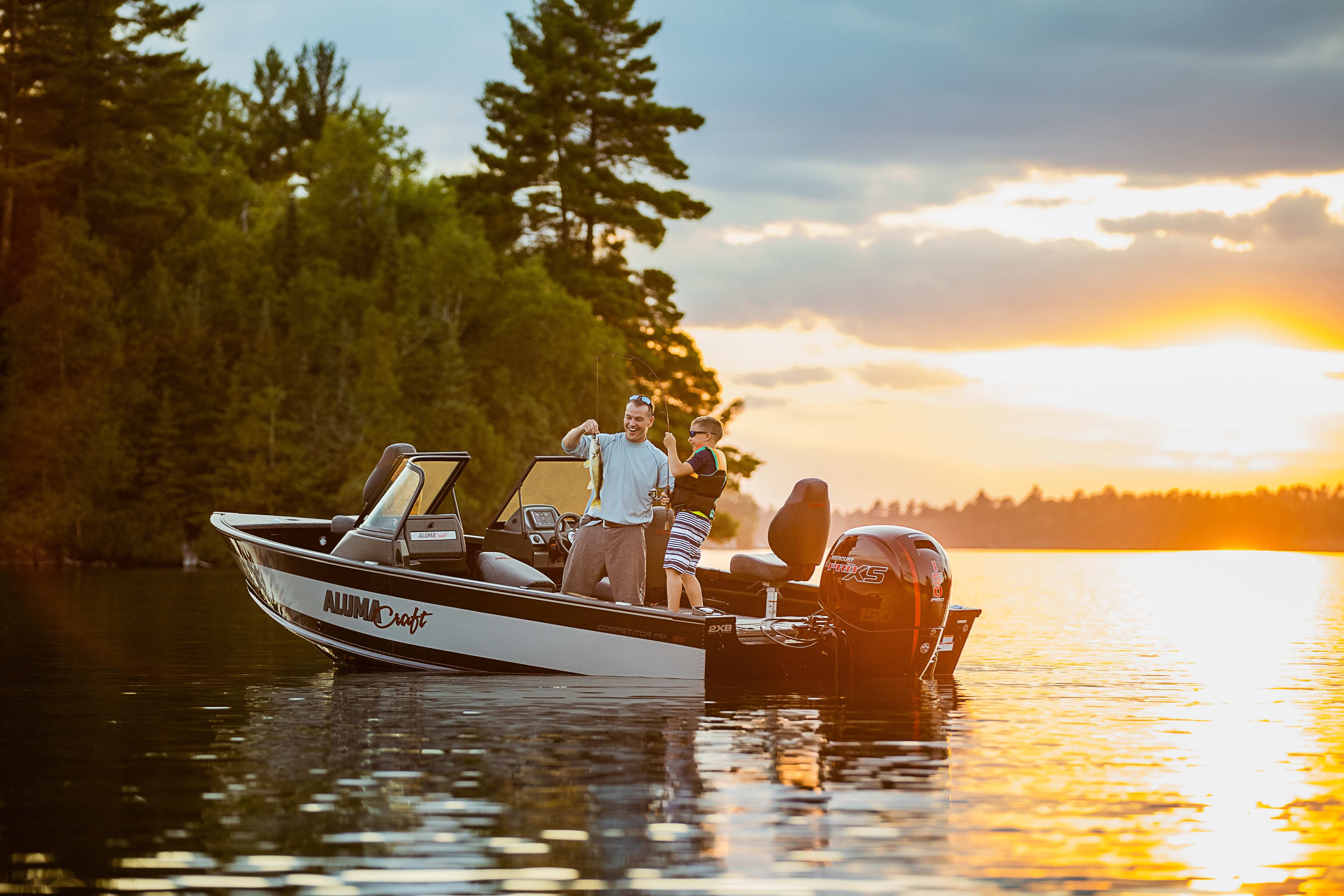 Dad and son fishing on a boat at the sunset