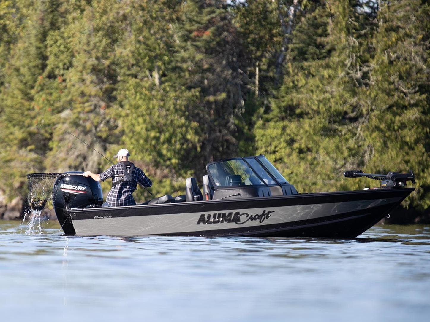 Man fishing with an alumacraft boat on still water