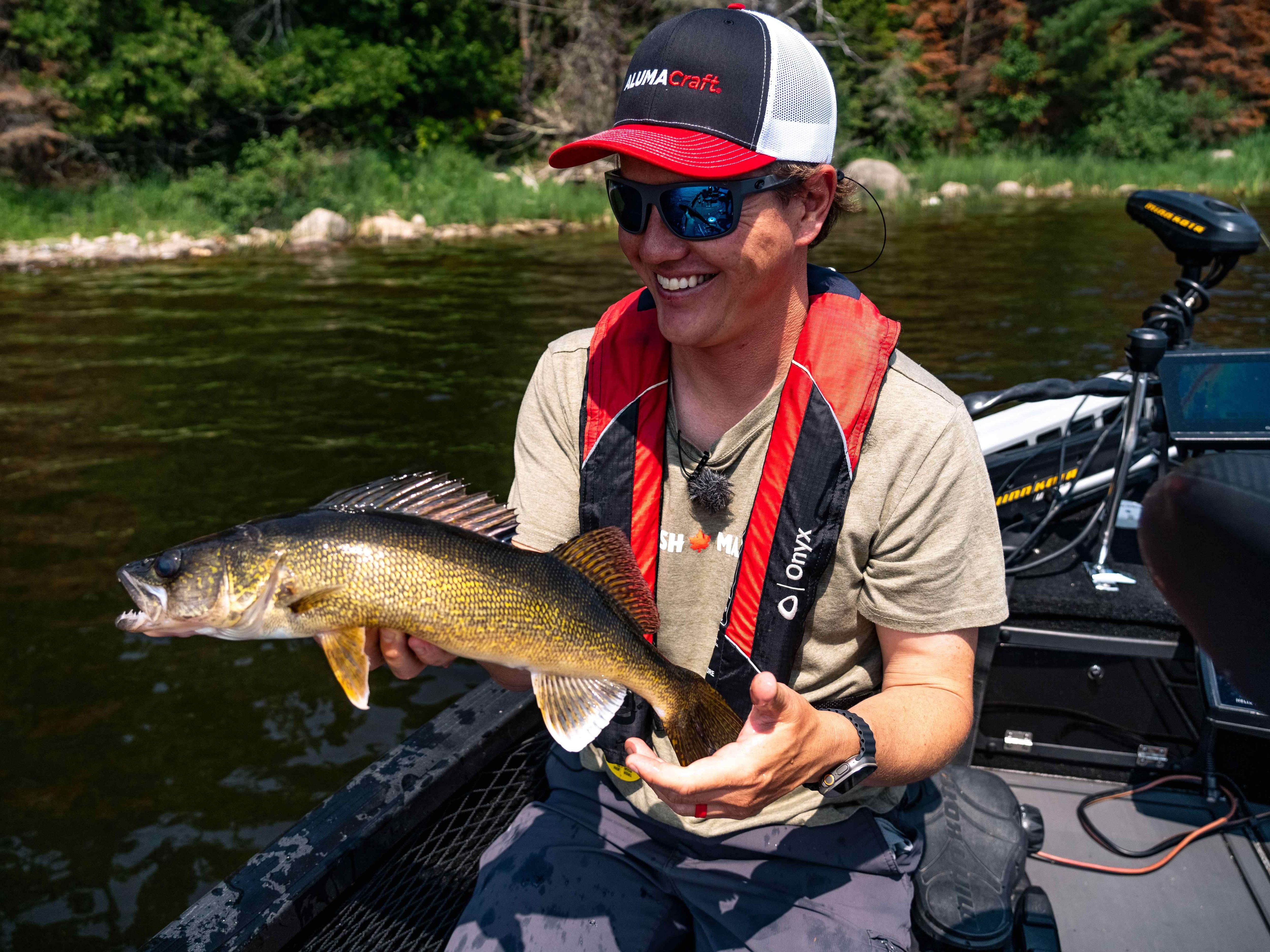 Jay Siemens holding a fish on his Alumacraft boat