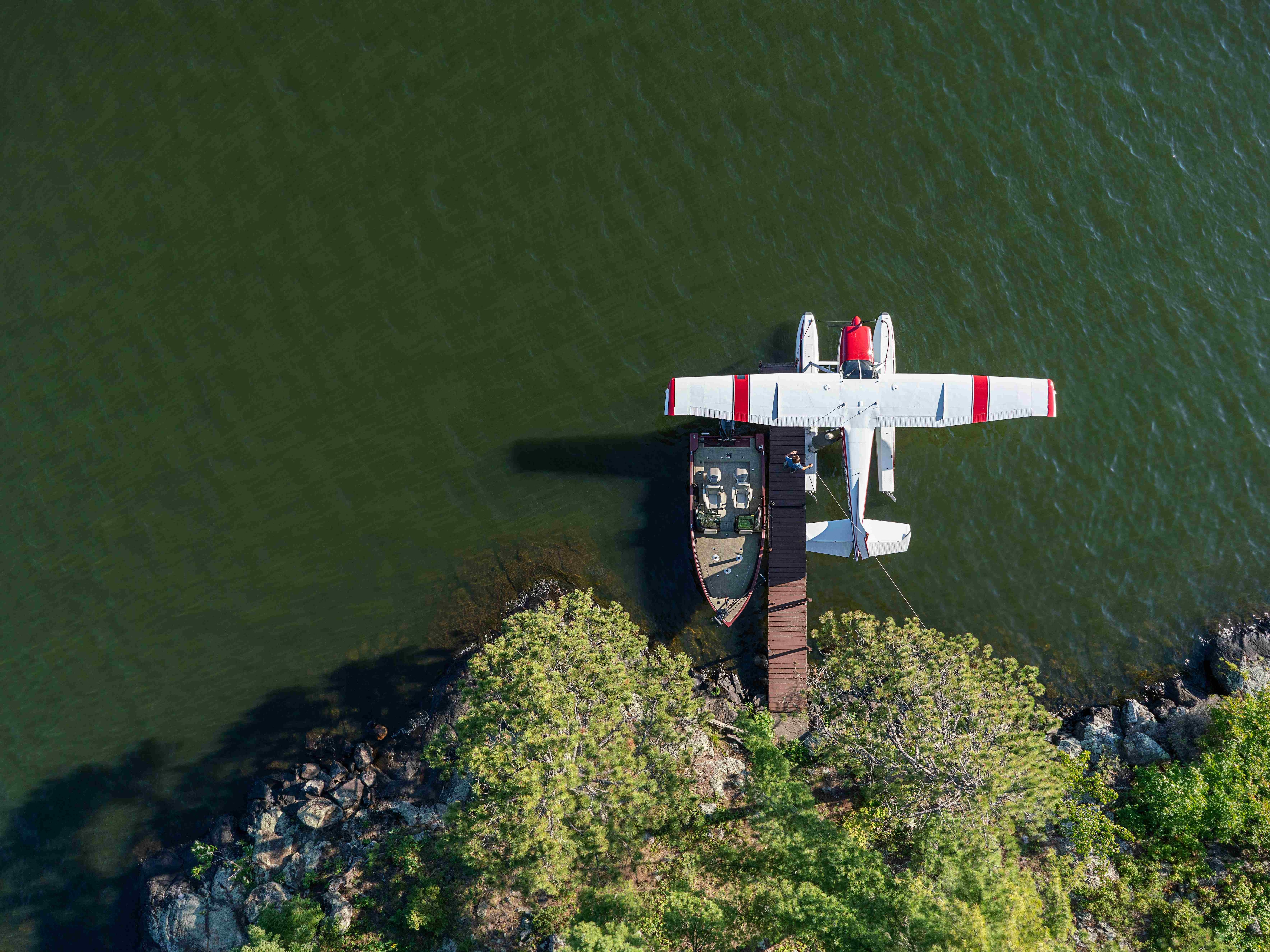 Aerial view of a plane and an Alumacraft fishing boat on the water.