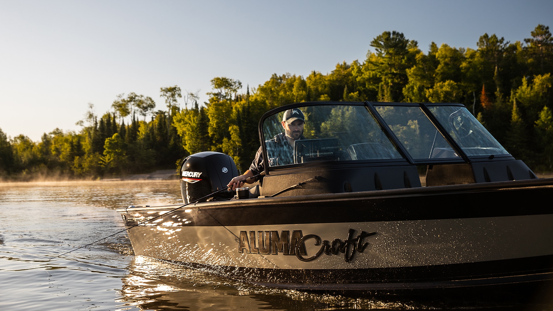 Man fishing on his Alumacraft boat at sunset