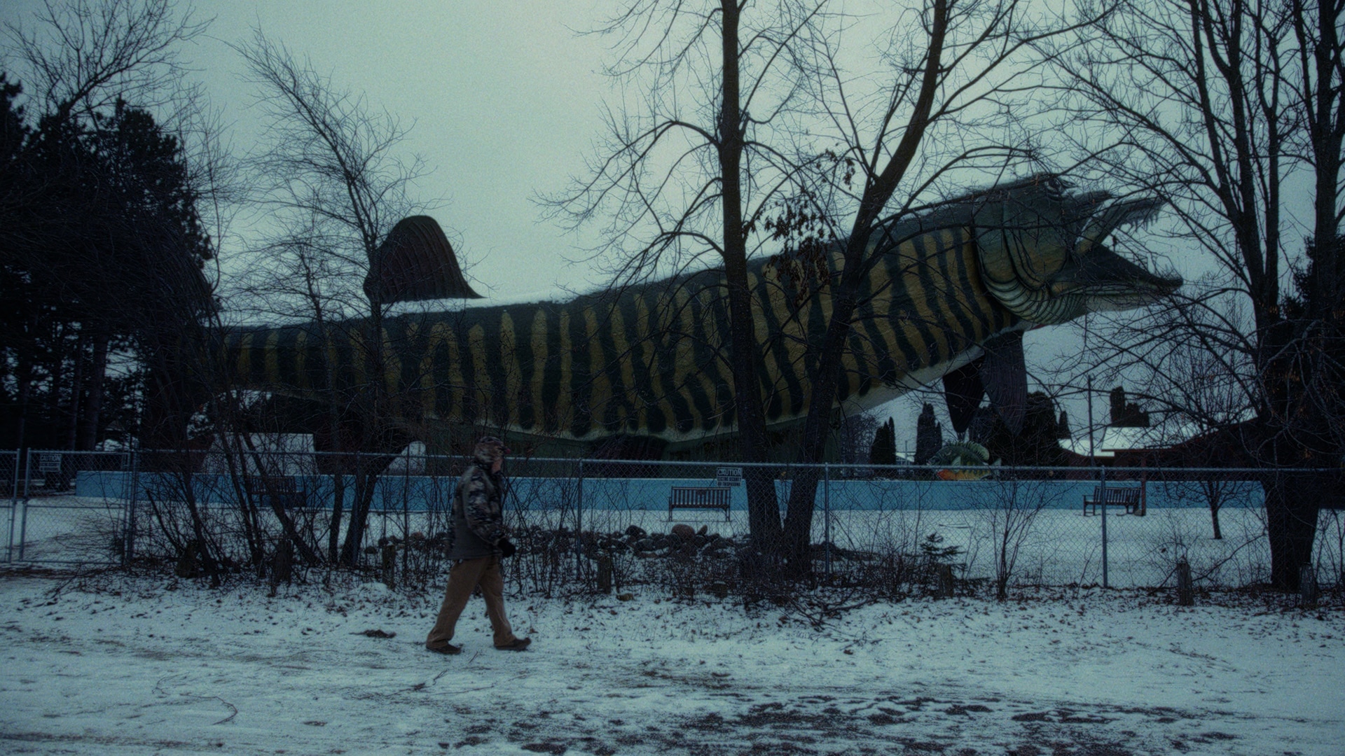 Ramsell aka &ldquo;MuskieMan&rdquo; walking in front of a huge fish statue